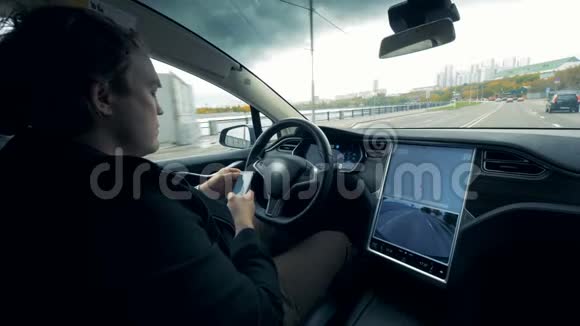 汽车在沿路行驶时司机正在浏览他的手机视频的预览图