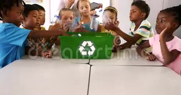 在教室里孩子们把垃圾桶放在回收箱里视频的预览图
