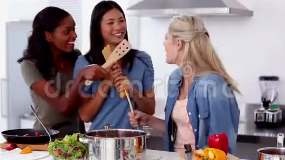 笑着的朋友在做饭的时候用木勺唱歌视频的预览图