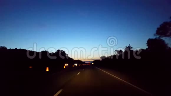 在地平线上用灯光驾驶早晨的高速公路司机观点POV州际驾驶清晨高速公路视频的预览图