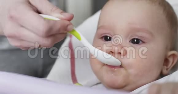 妈妈用勺子喂她8个月大的小宝宝视频的预览图