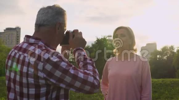 男性养老金领取者在公园里拍照爱好约会视频的预览图