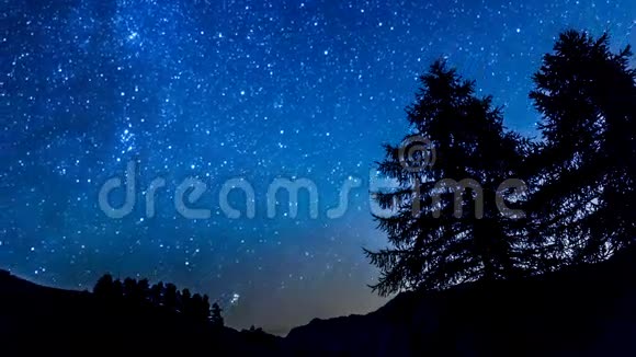 时光流逝的夜空星辰山和树的轮廓视频的预览图