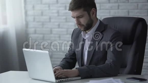 商人在笔记本电脑上回复电子邮件考虑即将达成的交易视频的预览图
