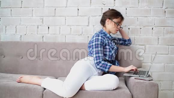 女人在家工作用她的笔记本电脑检查工作电子邮件视频的预览图
