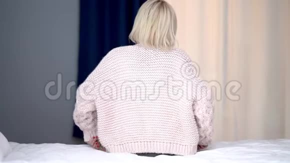 坐在床上有背痛问题的成年妇女视频的预览图