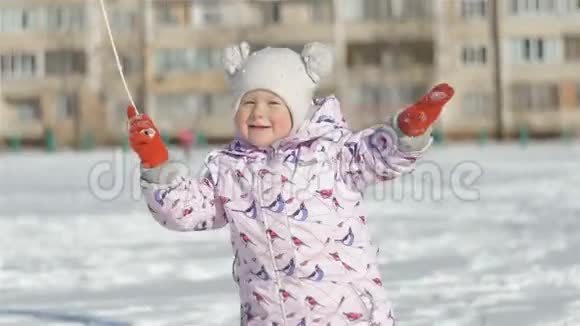 微笑着的小女孩在学校附近的雪地体育场上跑着视频的预览图
