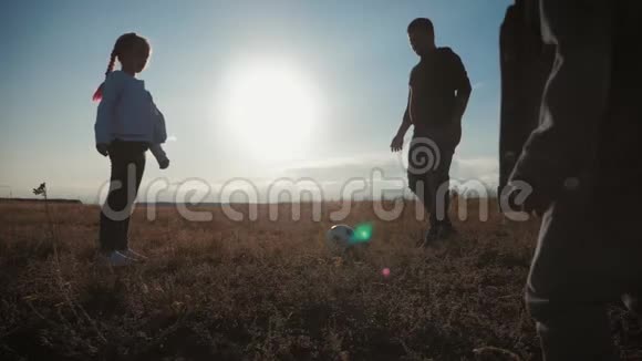 父亲和两个孩子在球场上踢足球运动概念视频的预览图