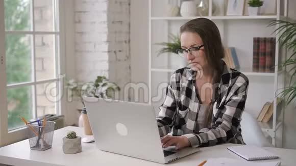 成功的女商人与笔记本电脑坐在投资光明公寓的桌子上视频的预览图