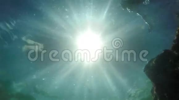 在阳光下跳跃的人的水下镜头慢动作录像视频的预览图