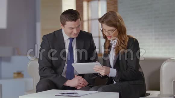 房地产经纪人向商人客户展示平板电脑上的照片视频的预览图