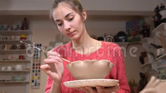 一般的观点一个女性陶匠平滑粘土锅边使用流苏在陶器车间视频的预览图