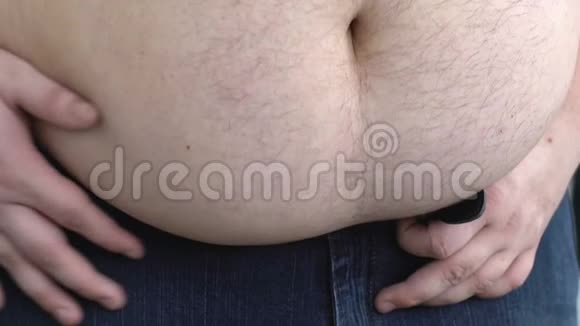 超重的人在收紧裤腰带的同时保持肥胖的胃视频的预览图