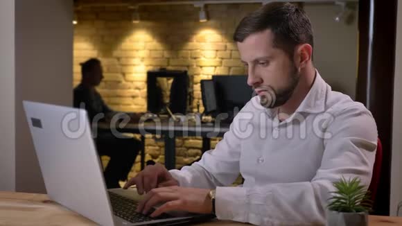 在办公室室内电脑上打字的白人成年人的特写照片视频的预览图