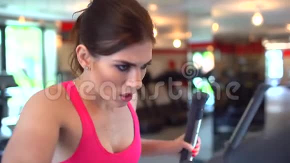 运动迷人的白种人年轻女子在健身房做有氧运动健身女孩穿粉色上衣的女运动员视频的预览图