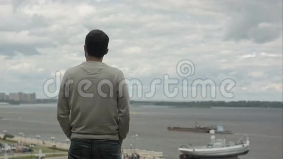 一个年轻的商人站在河边向前看思考视频的预览图