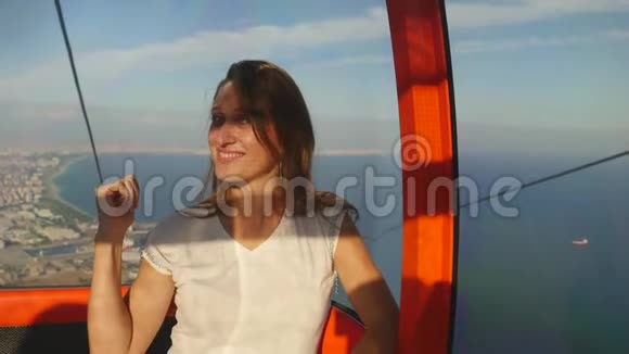 年轻的女游客坐在缆车上到达库涅克提佩Teleferik山顶视频的预览图