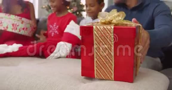 在家给孩子送圣诞礼物的父母女孩打开盒子拿出一只可爱的玩具驯鹿视频的预览图