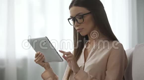 戴眼镜的优雅女士分析电子邮件信件检查平板电脑的收件箱文件夹视频的预览图