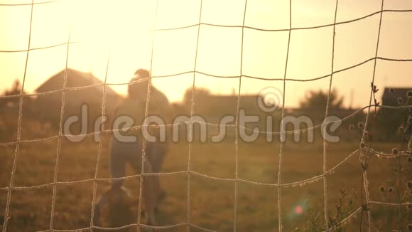 两个男孩在日落时踢足球一个足球正在击球足球进球孩子们胜利的梦想视频的预览图