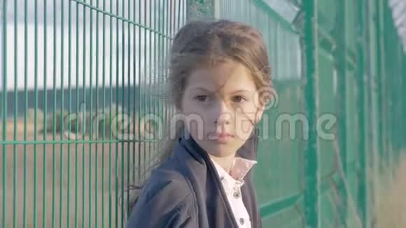 无家可归的难民儿童高加索小女孩站在金属栅栏前的肖像她既不快乐又怨恨视频的预览图