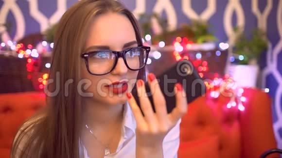 关闭商务女性在智能手机上使用免提电话室内一幅美丽的年轻女子在谈论视频的预览图