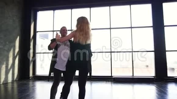 一对跳舞的萨尔萨舞年轻夫妇在舞厅跳舞视频的预览图