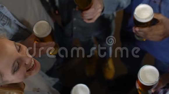 快乐的朋友在酒吧里碰啤酒杯下班后晚上娱乐视频的预览图