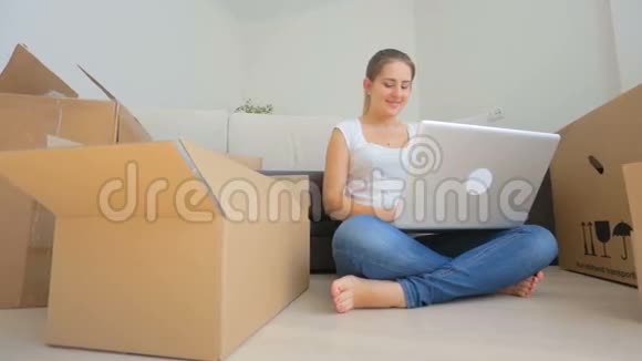 一张快乐的年轻女人搬到新房子里用数码平板电脑拍的照片视频的预览图