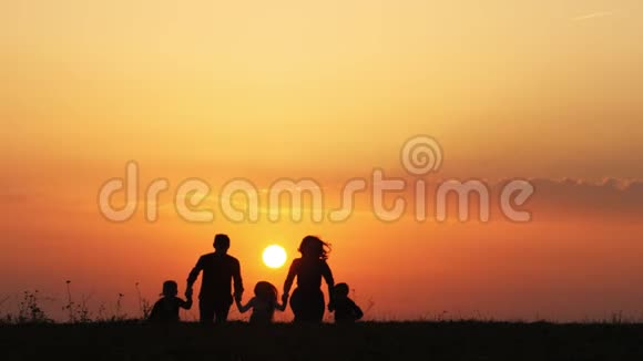 日落时一家人牵着手在草地上奔跑视频的预览图