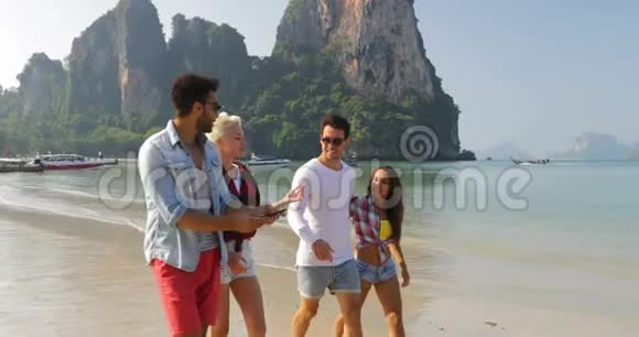 沙滩上的人们团体在手机上拍照智能手机上拥抱快乐的男女游客视频的预览图