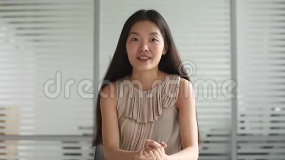 年轻的亚洲商界女性看着相机或网络摄像头说话视频的预览图