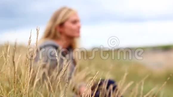 金发女人在沙丘上放松视频的预览图