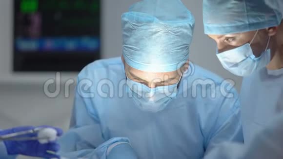 在医院手术期间助理擦拭主刀医生前额视频的预览图