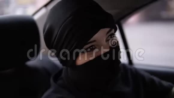 快乐快乐的穆斯林女人穿着黑色的niqab坐在车后座听着他们的音乐和舞蹈好心情视频的预览图