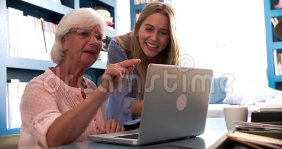 女儿在家庭办公室用电脑帮助老母亲视频的预览图