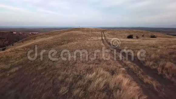 飞越乡间的道路穿过旱地和丘陵视频的预览图