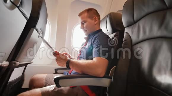 飞机上的一位年轻游客在离开前使用平板电脑视频的预览图