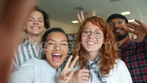 多种族的年轻人在大学图书馆微笑自拍视频的预览图