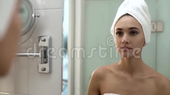 面部皮肤护理女人在浴室里涂抹护肤霜视频的预览图