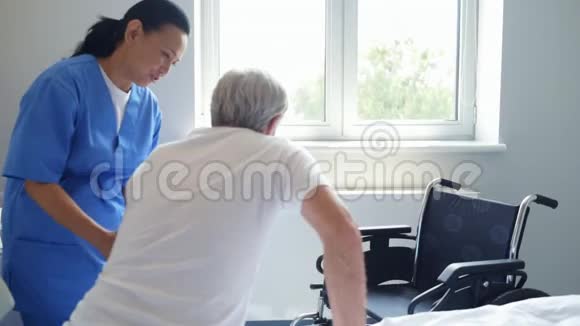 专业女医生帮助她的病人坐在轮椅上视频的预览图