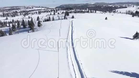 在山上飞上白雪覆盖的道路空中4k无人机电影视频的预览图