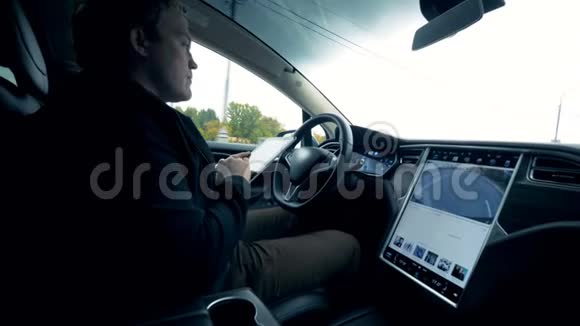 一个手里拿着平板电脑的人开车视频的预览图