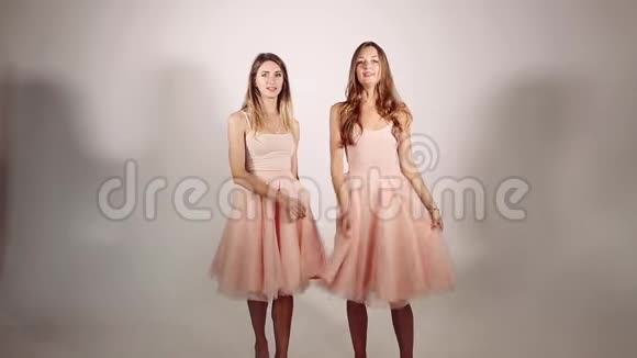 女孩子绕着裙子转卷着裙子从风和女孩的运动中升起两个漂亮可爱的女孩视频的预览图