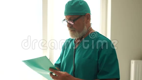 微笑的灰胡子医生拿着一份档案病人病史医药和保健概念视频的预览图