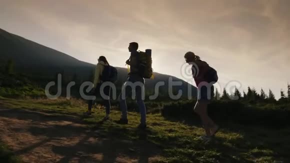 一群背着背包的朋友上山在夕阳的光芒中积极的生活方式视频的预览图