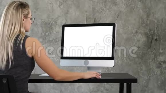 年轻的商务女性在办公室内部工作在电脑上办公桌打字看屏幕白色显示器视频的预览图