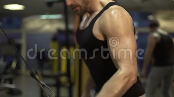 一个人在健身房里努力工作用一只手臂快速地拉下完成锻炼视频的预览图