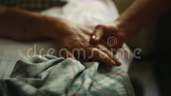 老人的一只手扶着她躺在床上视频的预览图