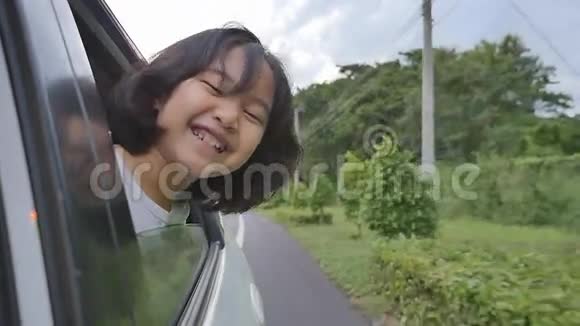 小女孩在车窗上玩耍家庭在农村旅行视频的预览图